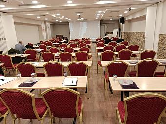 Conference room with classroom seating, projector screen and flipchart for team meetings.