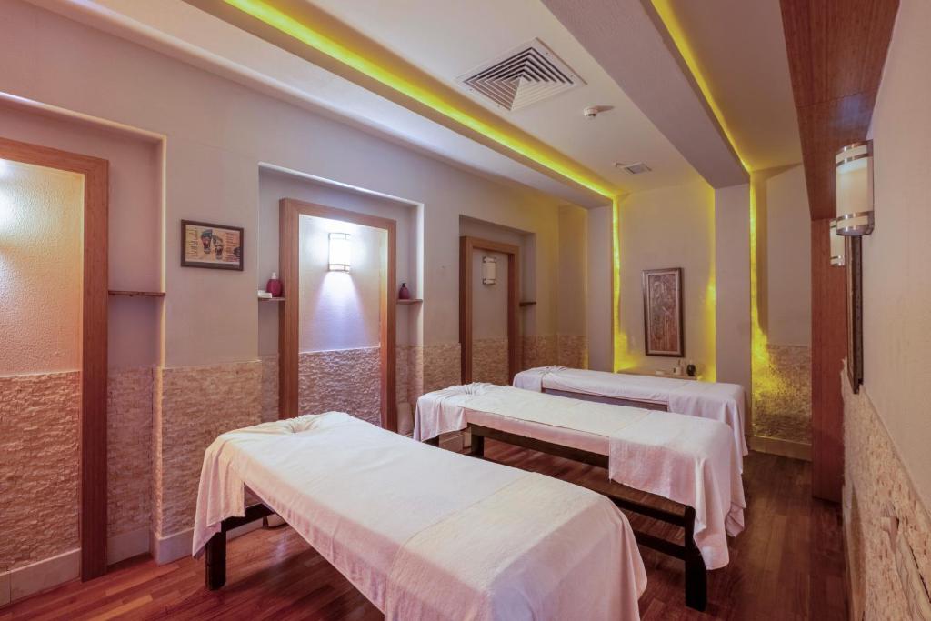 Salle de soins spa avec trois tables de massage pour récupération des athlètes.