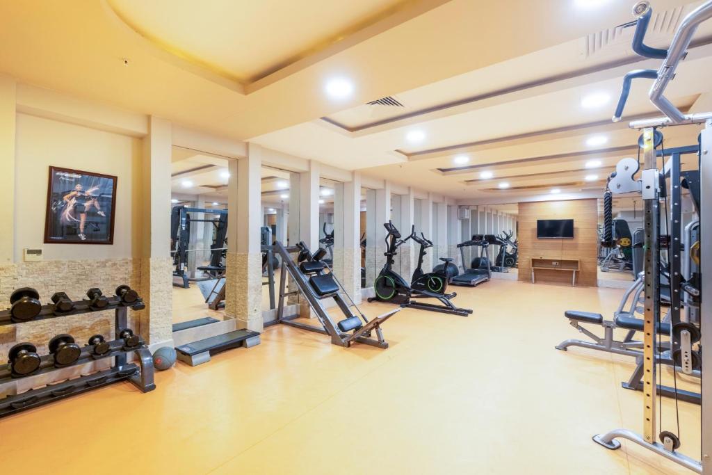 Salle de sport avec haltères, appareils cardio et postes de musculation pour entraînements de stage.