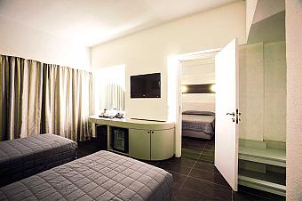 Guest room with twin beds, desk, minibar and a separate sleeping area.