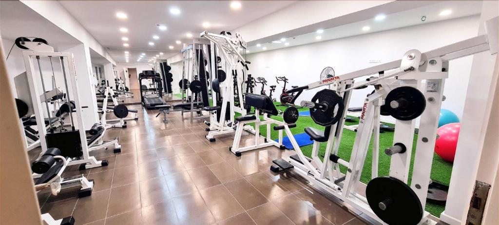 Fitness room with strength machines, treadmill and indoor training space.