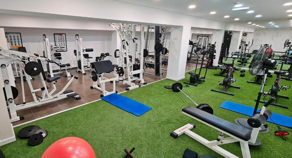 Gym with free weights, benches, bikes and a turf workout area.