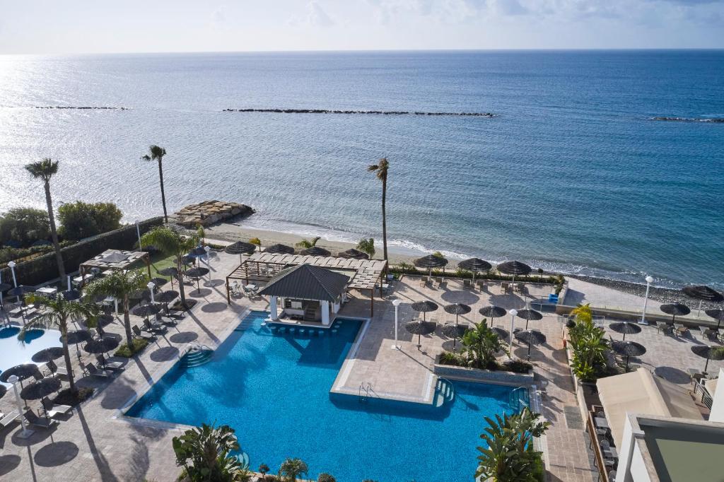 Luftaufnahme von Poolterrasse, Strand und Meer des Resorts.