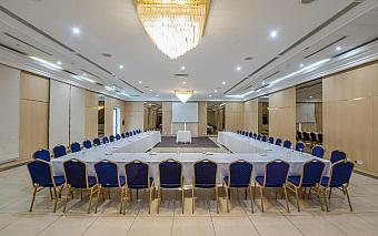 Conference room with U-shaped seating and projection screen.