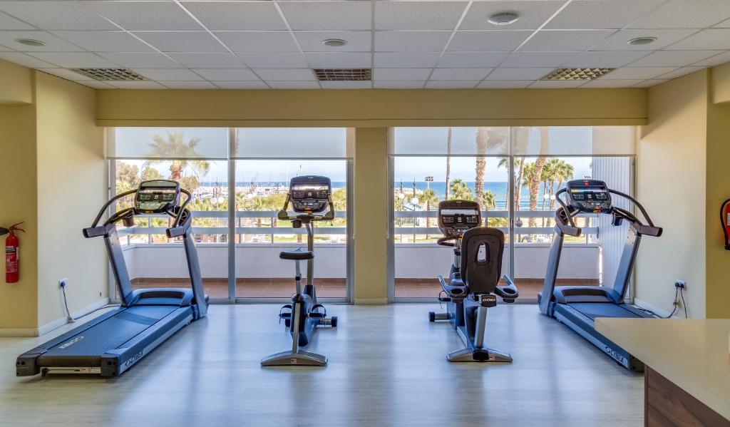 Heller Fitnessraum mit Laufbändern, Fahrrädern und Meerblick.