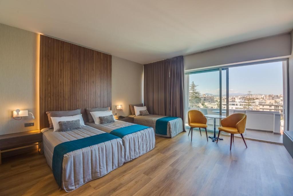Gästezimmer mit zwei Betten, Schlafsofa und Sitzbereich am Balkon.