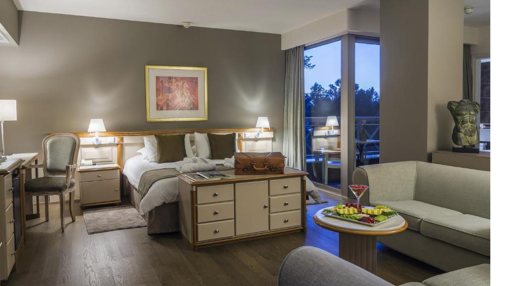 Spacious guest room with double bed, seating area and balcony access.