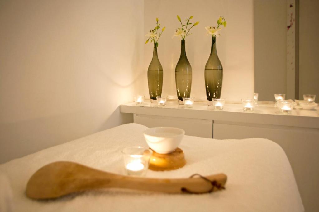 Spa treatment room with massage bed, candles and flower vases for recovery sessions.