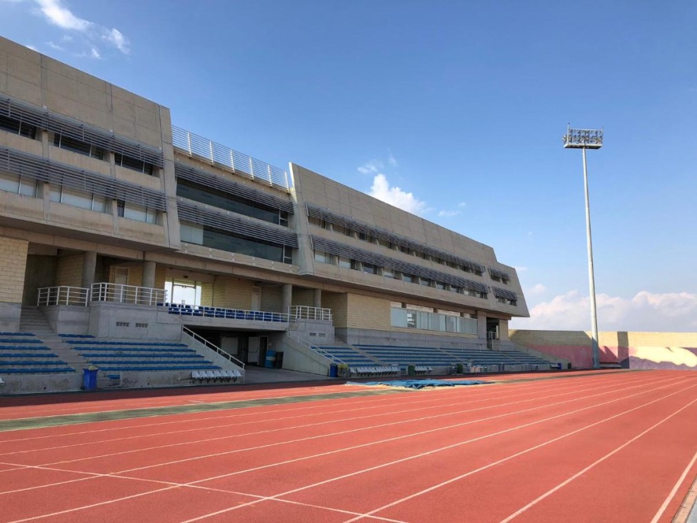 Leichtathletik-Trainingsanlage mit roten Laufbahnen und Zuschauertribünen an einem sonnigen Tag