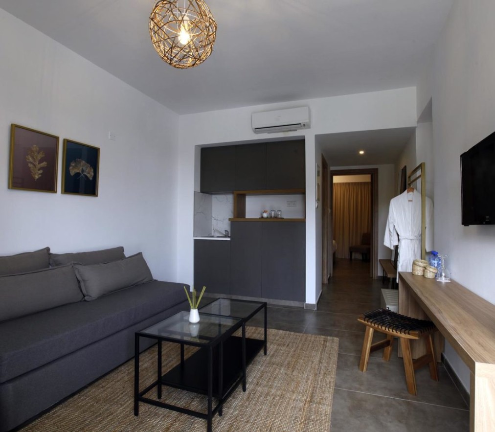Wohnbereich mit grauem Sofa, Tisch und minimalistischem Design in neutralen Farben