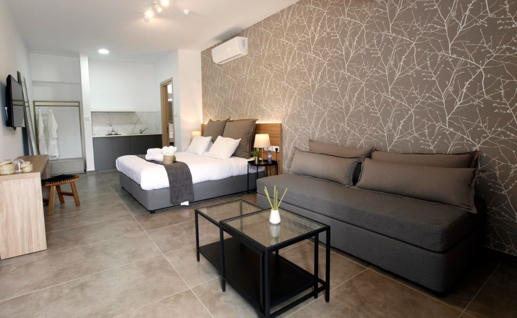 Geräumige Suite mit Doppelbett, Sofa und modernem Dekor in Grautönen und gemusterter Wand