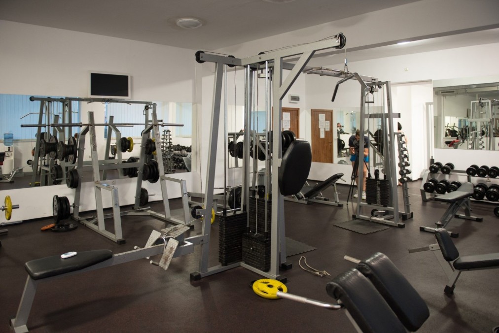 Fitnessstudio mit Kabelzugmaschinen, Bänken und Freihanteln für Krafttraining im Trainingslager