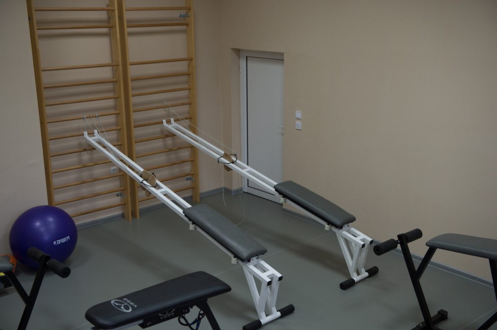 Kleiner Trainingsraum mit Bänken, Sprossenwand und Gymnastikbällen für Rehabilitations- oder Konditionstraining