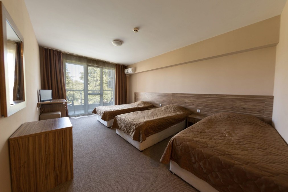 Hotelzimmer mit drei Einzelbetten, Schreibtisch und Fenster, Teamunterkunft für Trainingslager