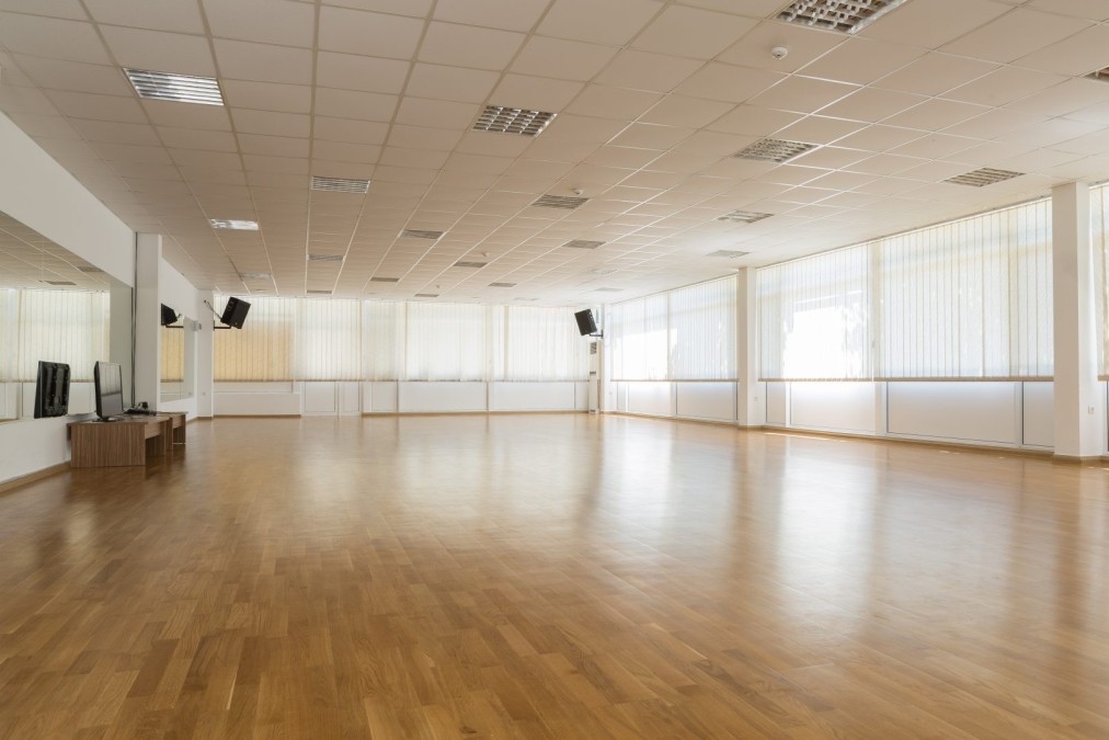 Helles Indoor-Studio mit Holzboden und Spiegeln, genutzt für Fitnessworkouts und Coaching-Sessions