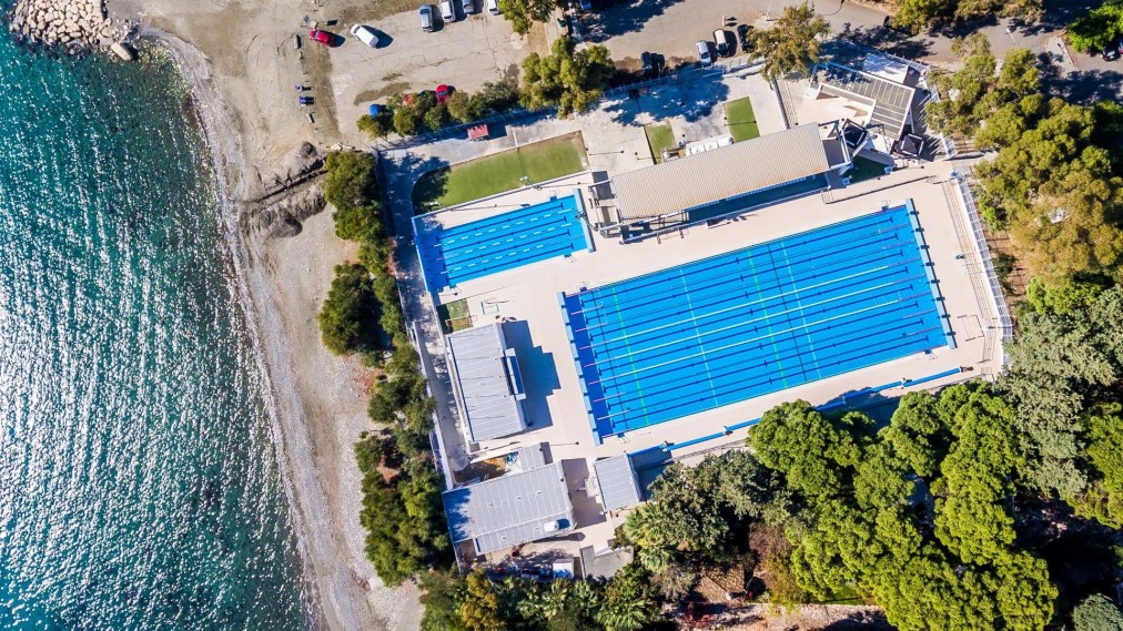 Draufsicht auf blaue Schwimmbecken neben dem Strand, ideal für Schwimmtrainingslager