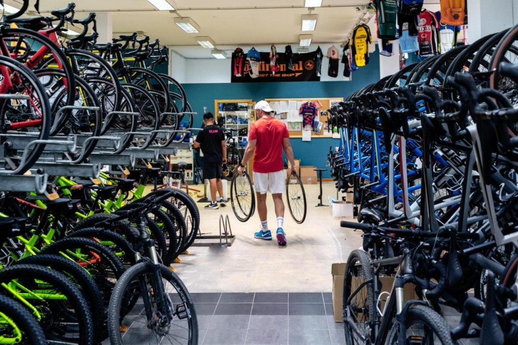 Fahrradwerkstatt und Verleih mit Reihen von Rennrädern und Ersatzlaufrädern.