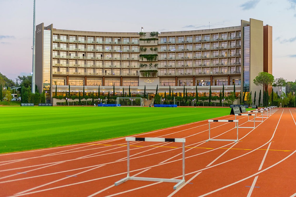 Leichtathletikbahn mit Innenfeld-Trainingsbereich und aufgebauten Hürden für Sprint- und Techniktraining. Flutlicht und viel Platz ermöglichen strukturierte Einheiten für Teams und Einzelsportler.