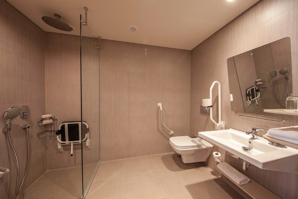 Heller, großzügiger Suite-Wohnbereich mit Lounge-Sitzgruppe, Esstisch und großen Fenstern für viel Tageslicht. Das komfortable Layout bietet Platz zum Entspannen, Arbeiten oder für kleine Besprechungen.