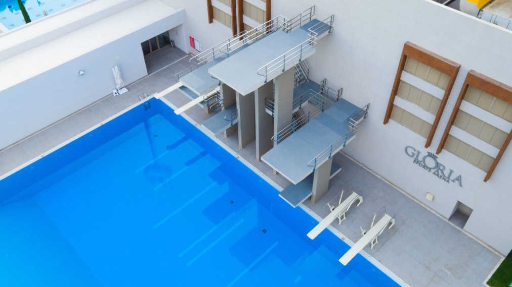 Indoor-Sprunganlage mit mehreren Plattformhöhen und Sprungbrettern für strukturiertes Training. Saubere Beckenumgänge und gute Sichtverhältnisse unterstützen Sicherheit und Coaching.