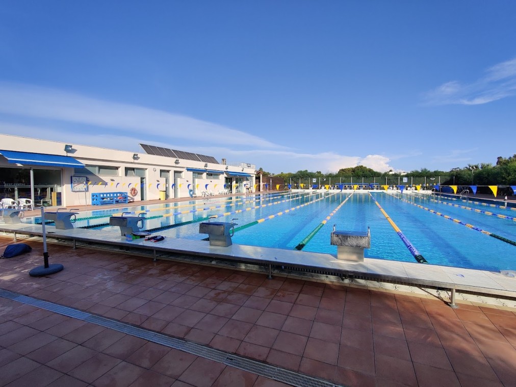 Außenpool mit Startblöcken, Schwimmleinen und Beckenumgang.