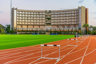 Leichtathletikbahn mit Innenfeld-Trainingsbereich und aufgebauten Hürden für Sprint- und Techniktraining. Flutlicht und viel Platz ermöglichen strukturierte Einheiten für Teams und Einzelsportler.