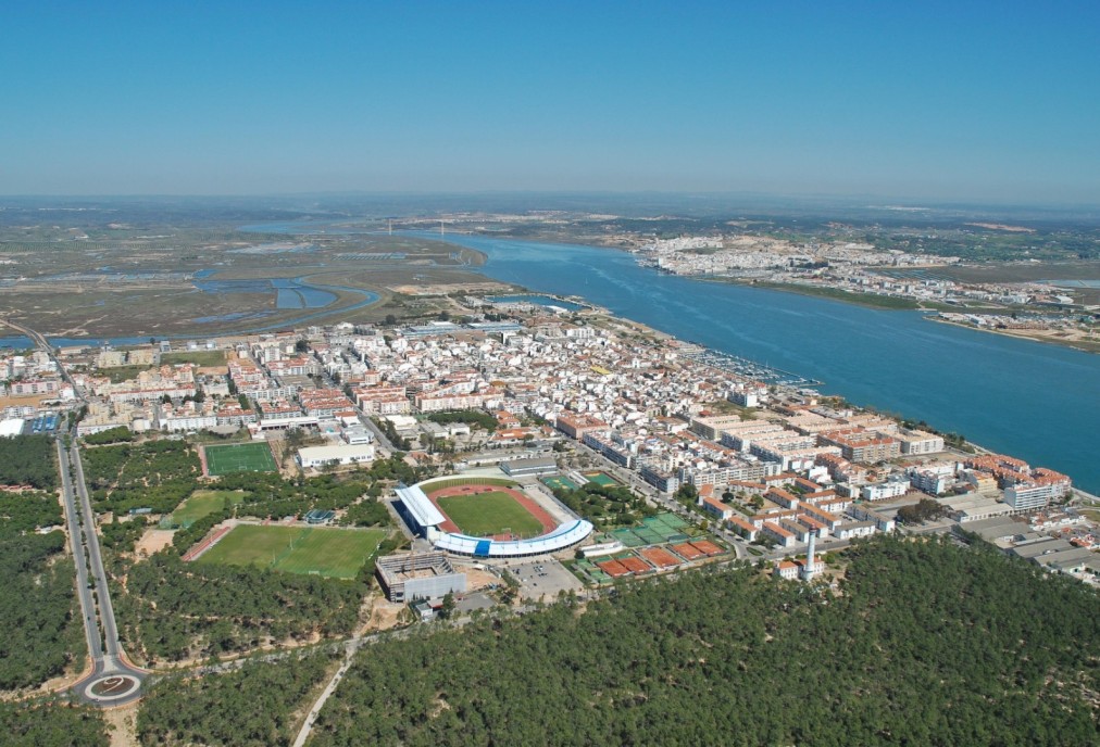 Luftaufnahme des Sportkomplexes am Fluss und neben der Stadt.