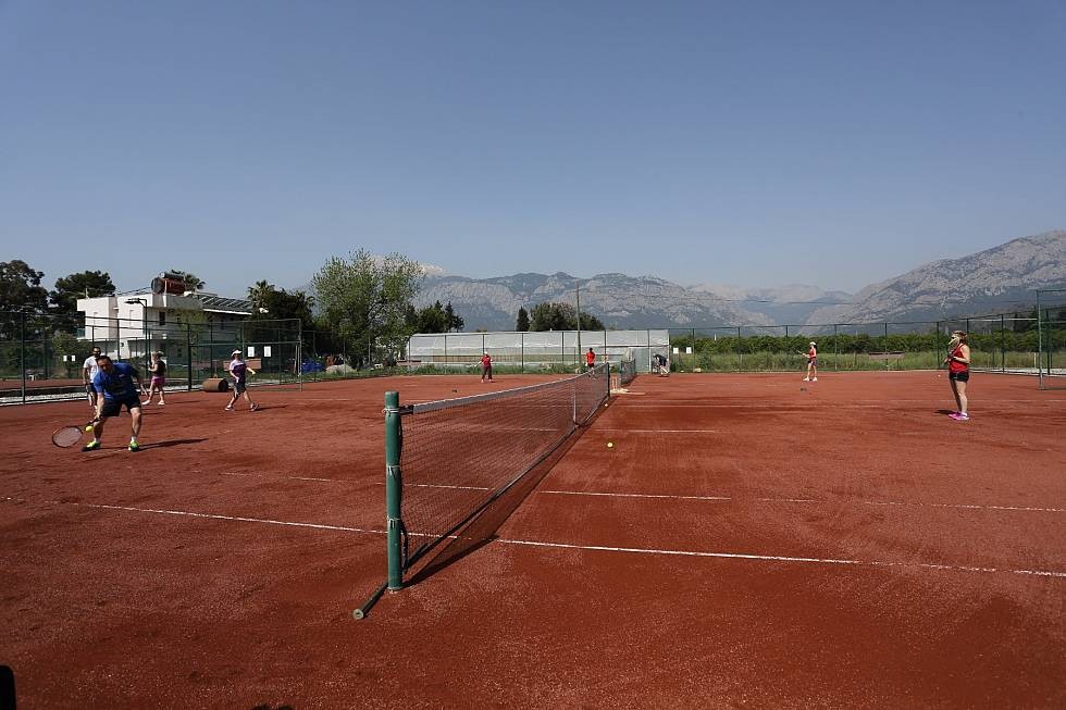 Sandplatz-Tennisplätze mit Spielern bei einer Doppel-Trainingseinheit.