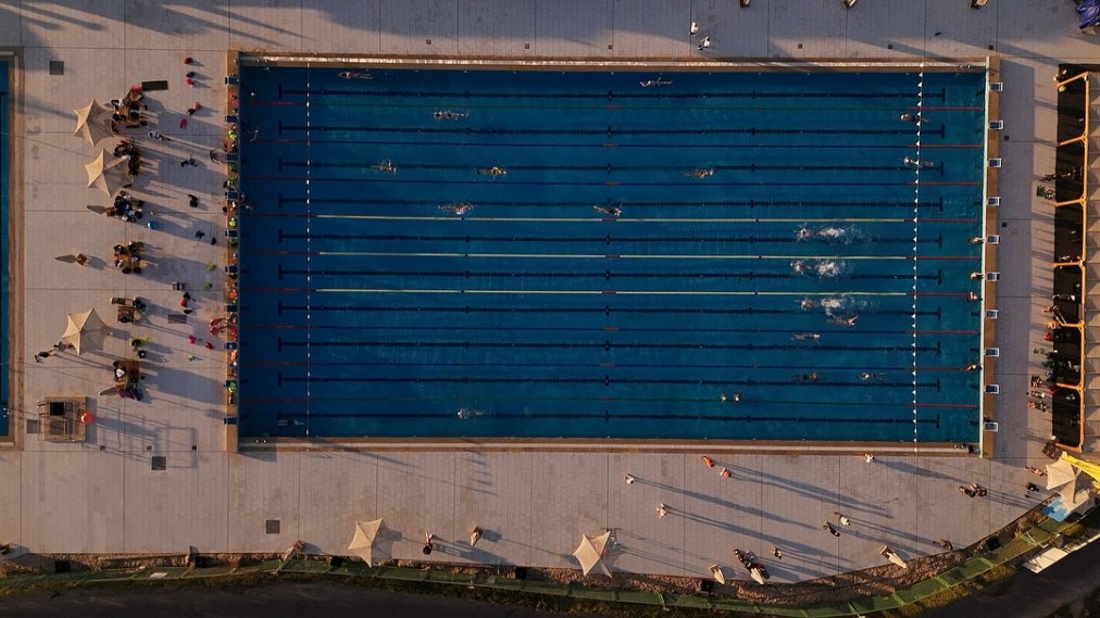 Draufsicht auf ein olympisches Schwimmbecken mit Schwimmern in den Bahnen