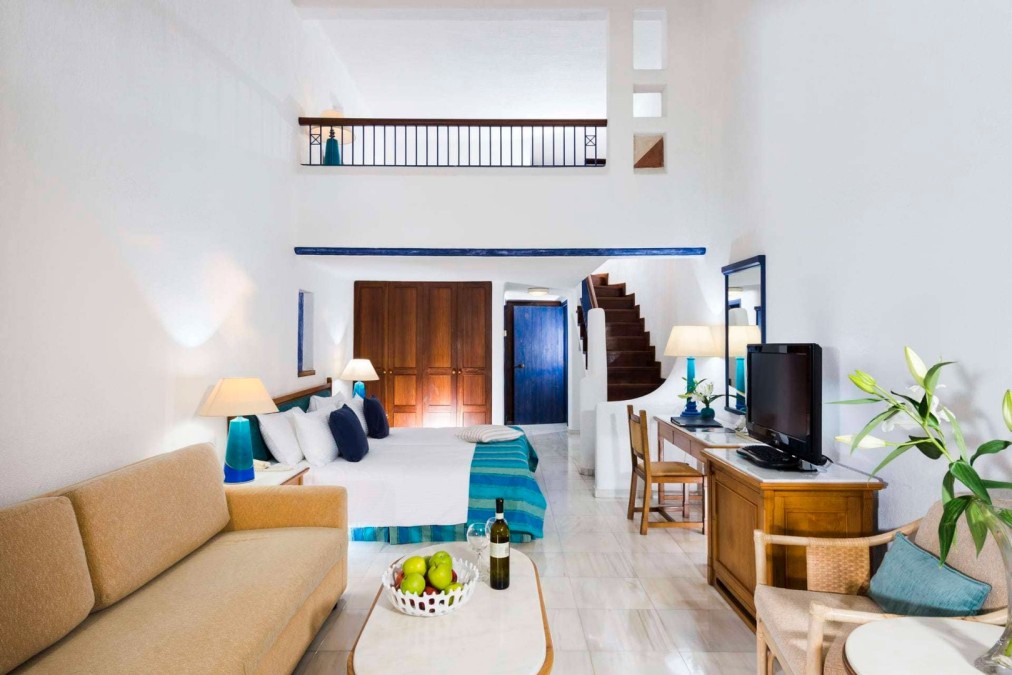 Maisonette-Gästezimmer mit Bett, Sitzecke und Treppe, ideal für die Unterbringung während eines Sportcamps