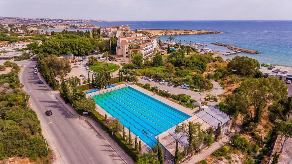 Sportanlage am Meer mit großem Außenpool und nahegelegenen Straßen