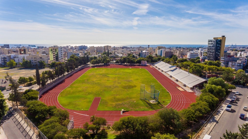 Weitwinkelansicht eines Leichtathletikstadions mit Bahn, Spielfeld und Tribünen in Meeresnähe