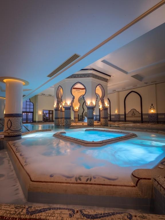 Innen-Thalasso-Pool mit maurischen Bögen und sanfter Abendbeleuchtung für Entspannung und Regeneration