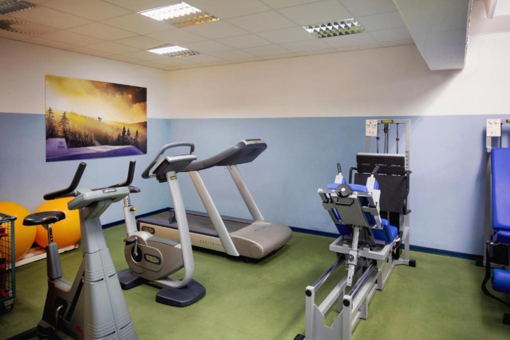 Kleiner Fitnessraum mit Laufband, Ergometer und Kraftgerät für Workouts.