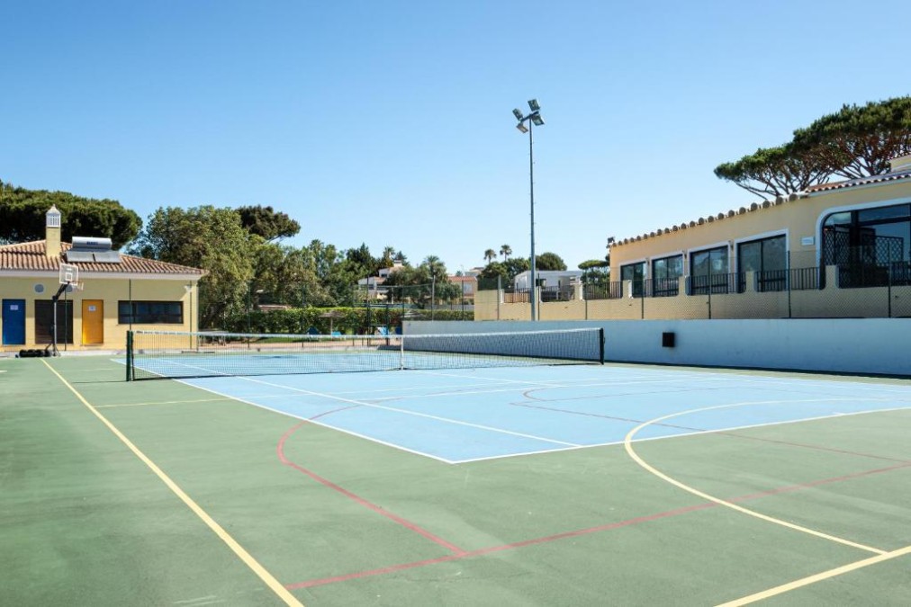 Außen-Multisportplatz mit Netz und Basketballkorb.