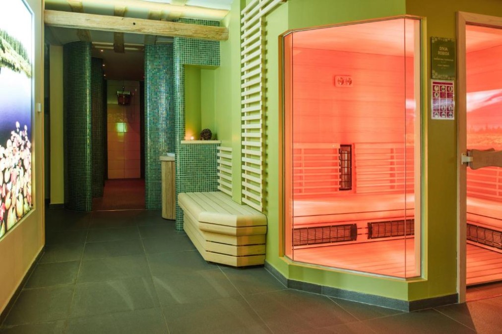 Sauna- und Wellnessflur mit Bänken, Mosaikwänden und sanfter Beleuchtung.