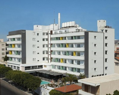 Außenansicht des Hotelgebäudes mit Balkonen, Poolbereich und umliegenden Straßen.