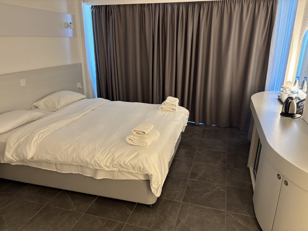 Doppelzimmer mit großem Bett, Schreibtisch, Minibar und Verdunkelungsvorhängen.
