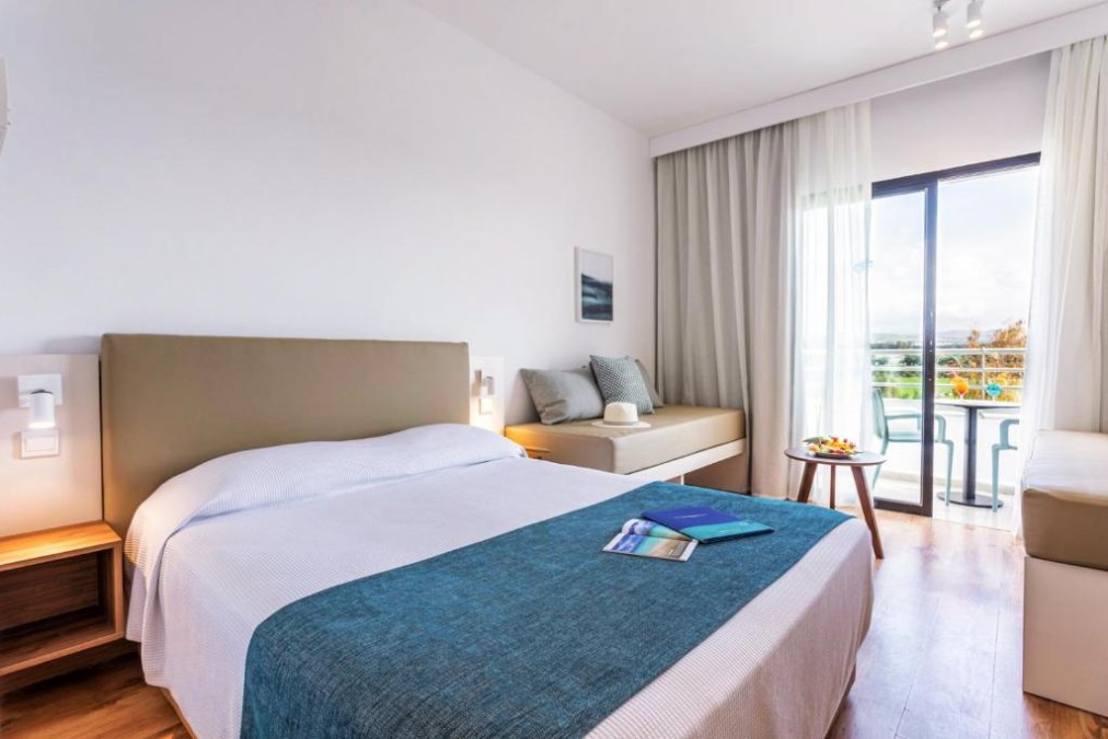 Gästezimmer mit Doppelbett, Sofa und Balkontisch.