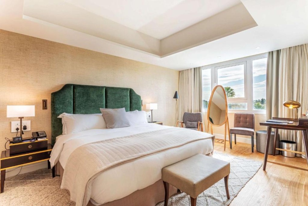 Premium-Zimmer mit Kingsize-Bett, Schreibtisch und freistehendem Spiegel.