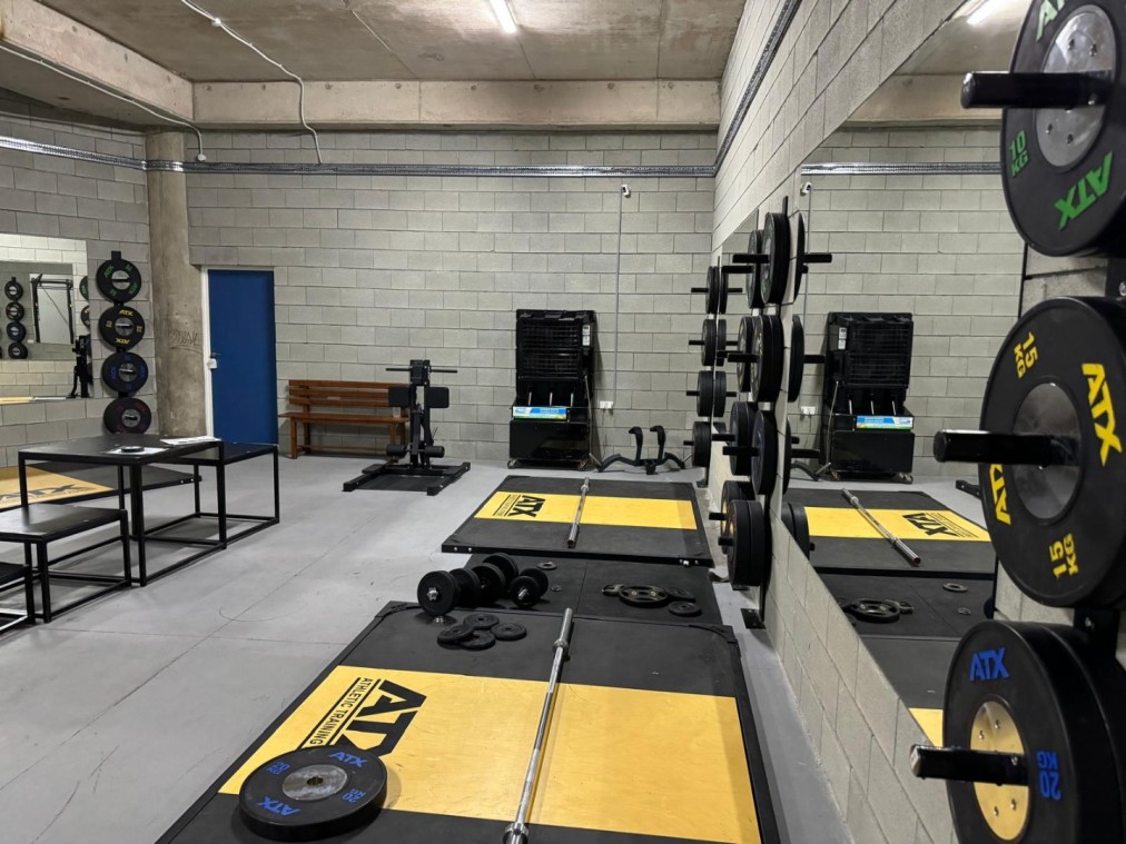 Installation de musculation avec haltères, disques de poids et supports pour exercices de conditionnement des athlètes