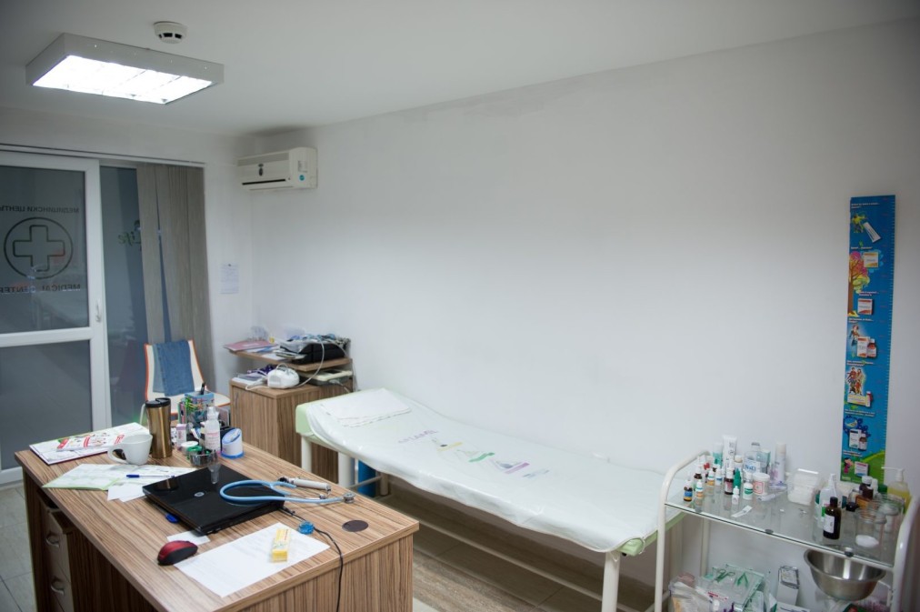 Salle de soins médicaux avec table d'examen, bureau et fournitures pour les soins aux athlètes pendant le stage d'entraînement