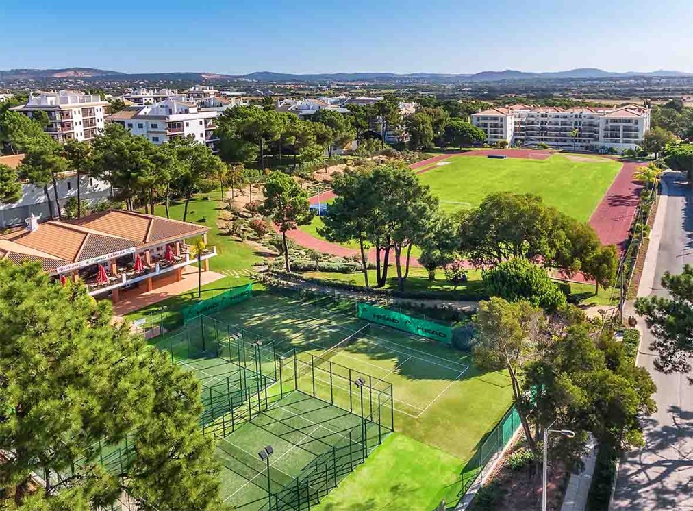 Vue aérienne de courts de padel et d'un stade d'athlétisme au sein du complexe.
