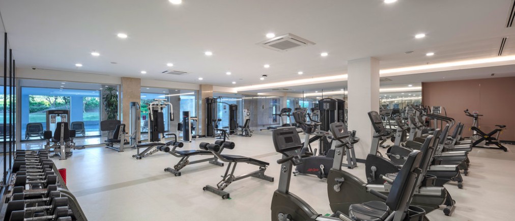 Salle de sport avec poids libres, appareils de musculation et équipements cardio