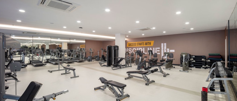 Salle de musculation avec bancs, haltères et équipements d'entraînement