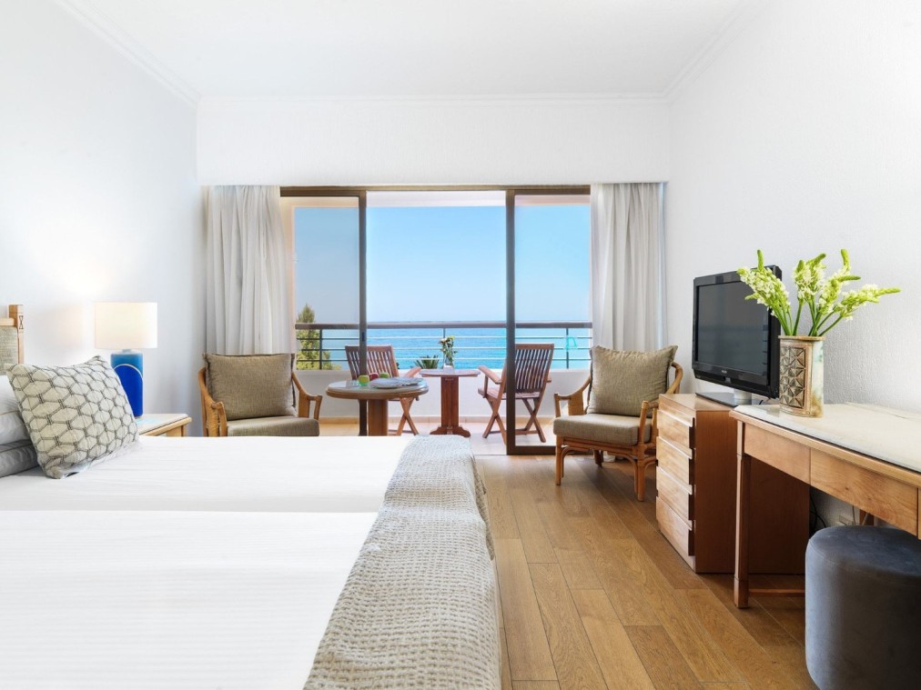 Chambre d'hôtel avec vue sur l'océan, balcon, parquet et coin salon pour le repos des athlètes