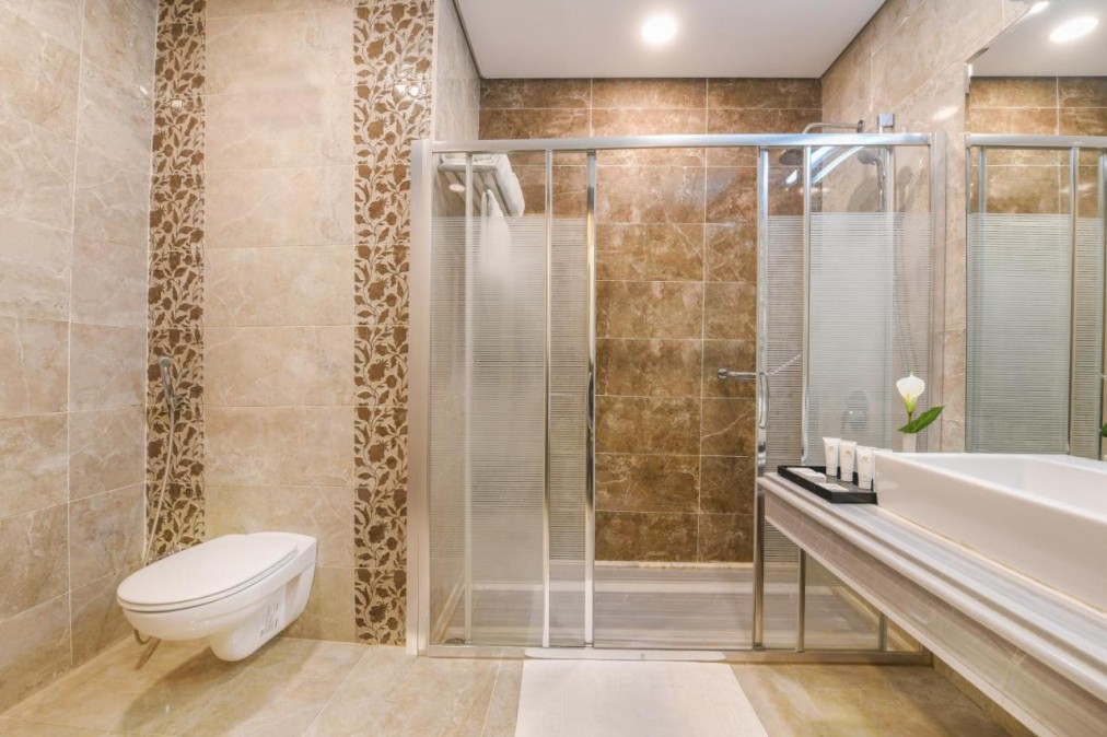 Salle de bain moderne avec douche à l'italienne, portes vitrées et murs carrelés