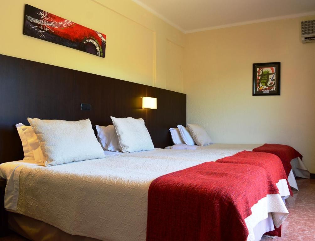 Chambre triple avec trois lits simples, décorations murales et lampes de chevet.